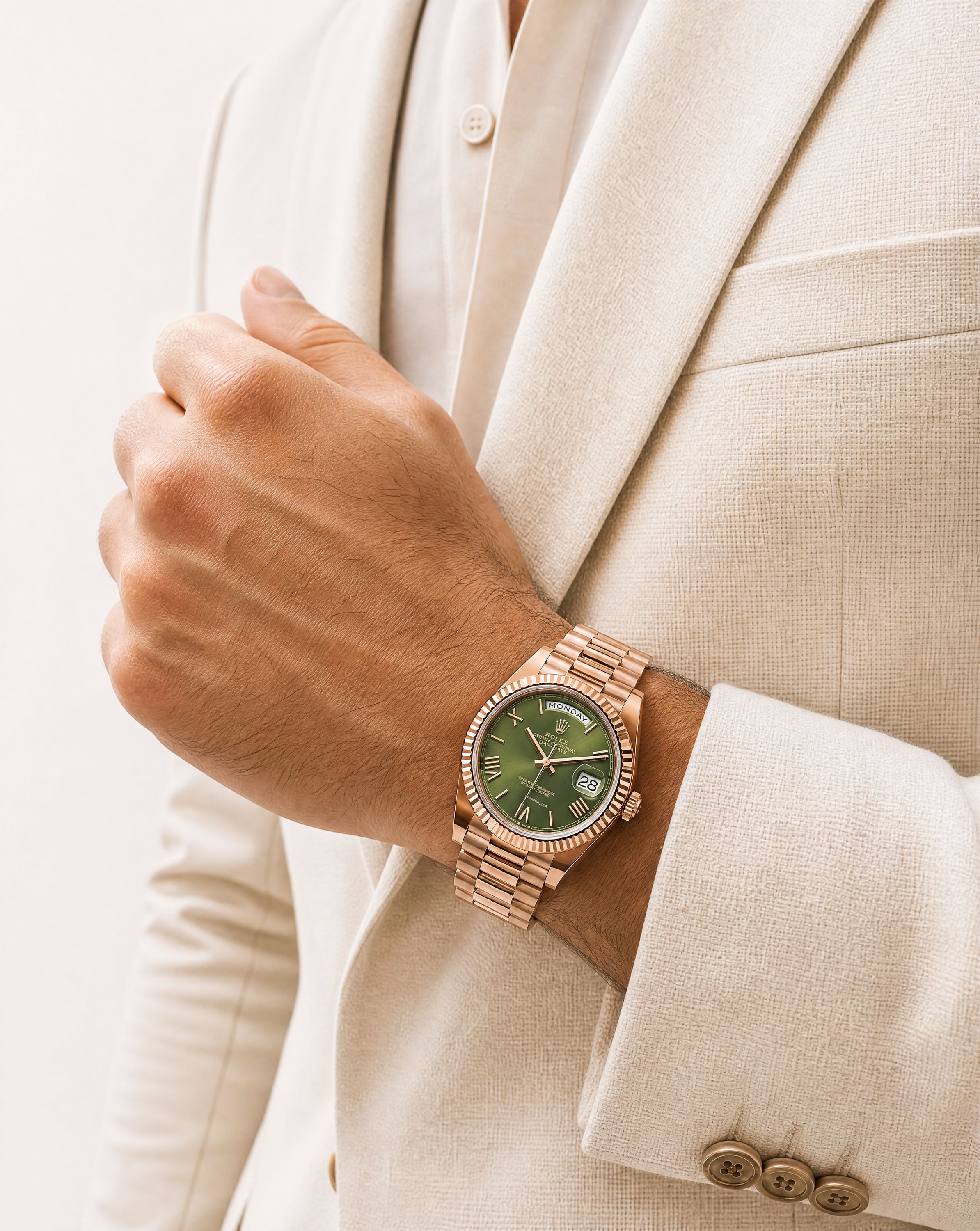 A rose-gold timepiece worn with a cream suit